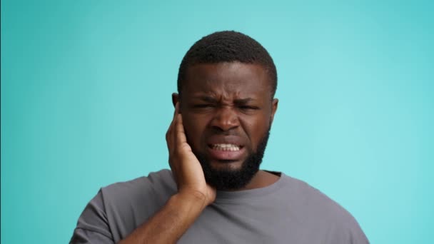Fülfájás. Boldogtalan fekete fickó szenved fülfájás, megható fájó terület és homlokráncolás - Felvétel, videó