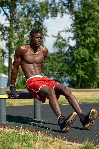 Ráno si zacvičím. Mladý silný africký muž ve sportovním oblečení cvičení venku. Sport, trénink. Zdravý aktivní životní styl. TRX - Fotografie, Obrázek