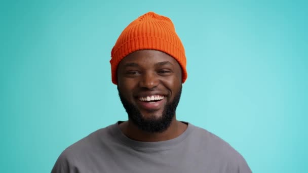 Duizendjarige man. gelukkig jong zwart man in oranje hoed glimlachen naar camera - Video