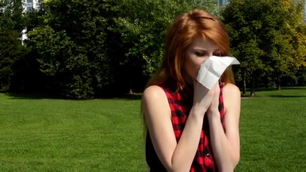ελκυστική κοπέλα είναι στο πάρκο - γυναίκα φυσώντας τη μύτη με μαντήλι - Πλάνα, βίντεο