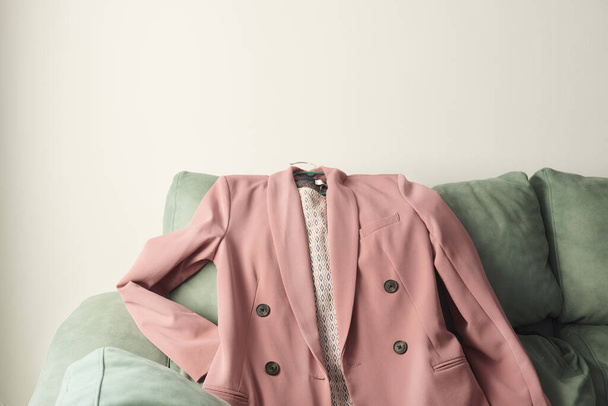 A rose pink jacket costume on a green sofa. - Fotoğraf, Görsel