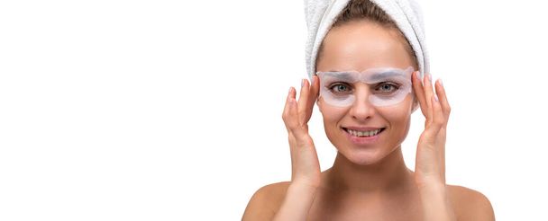 Nainen, jolla on kosmeettisia laikkuja silmien ympärillä suihkun jälkeen valkoisella taustalla - Valokuva, kuva