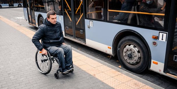 Person with a physical disability exits public transport with an accessible ramp. - Foto, afbeelding