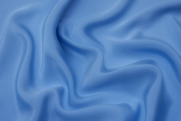 Zbliżenie tekstury naturalnej niebieskiej tkaniny lub materiału w tym samym kolorze. Tekstura tkaniny z naturalnej bawełny, jedwabiu lub wełny lub lnu materiału włókienniczego. Niebieskie tło płótna. - Zdjęcie, obraz