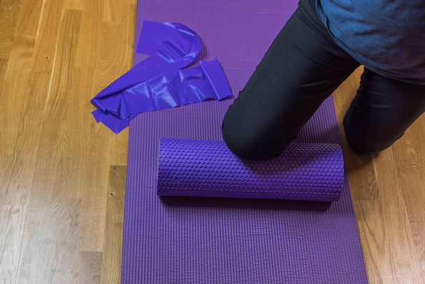 Vue rapprochée des jambes de la femme sur le tapis d'entraînement après l'exercice à la maison. Suède. - Photo, image
