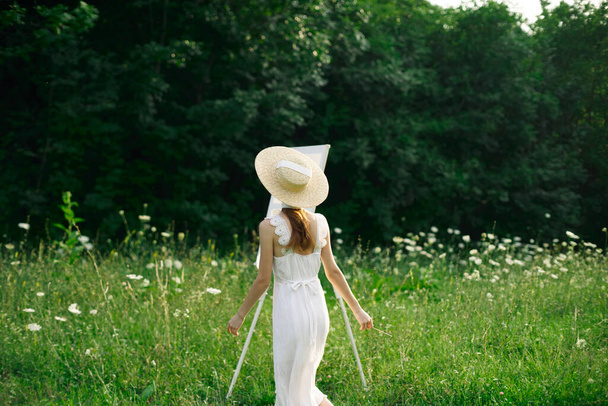 pretty woman in white dress outdoors easel art - Fotoğraf, Görsel