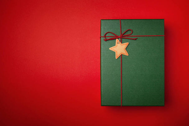 Green present or Christmas box on a red background. - Foto, Imagen