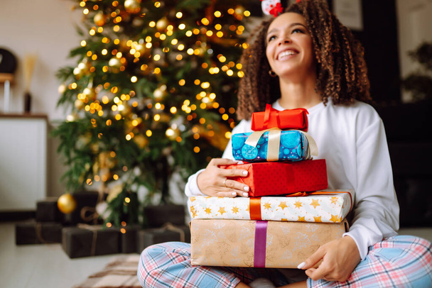 Portrait of happy woman celebrating winter holidays with large gift boxes near Christmas tree. Christmas surprise. - Fotografie, Obrázek