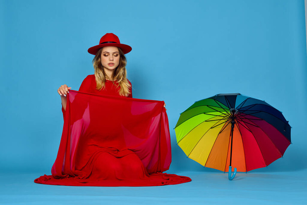 woman in red dress multicolored umbrella blue background - Photo, Image