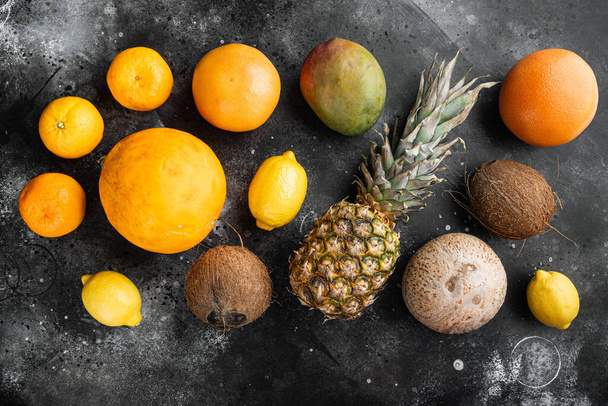 Fresh tropical fruit set, on black dark stone table background, top view flat lay - Foto, afbeelding