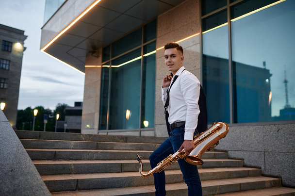 Saxofonista masculino con saxofón en la calle por la noche - Foto, imagen