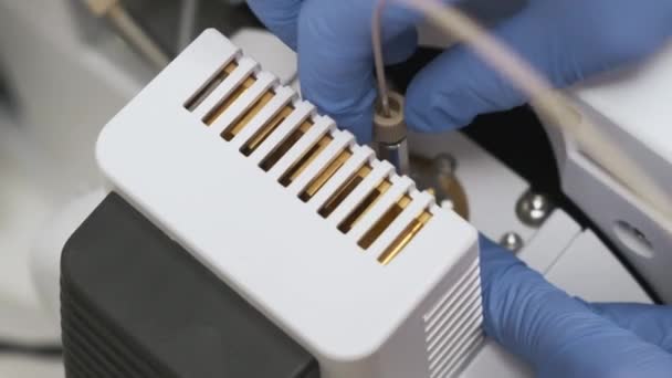 Técnico de laboratorio desenrosca el capilar en la aguja del nebulizador en fuente iónica del detector de masa de LC MS qTOF. - Imágenes, Vídeo