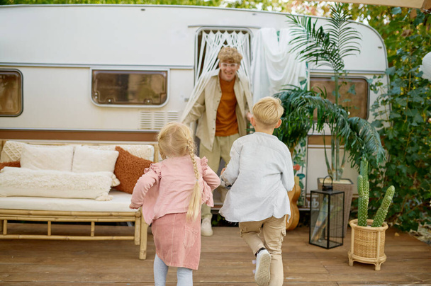 Isä ja lapset leikkivät asuntovaunussa telttailemassa. - Valokuva, kuva