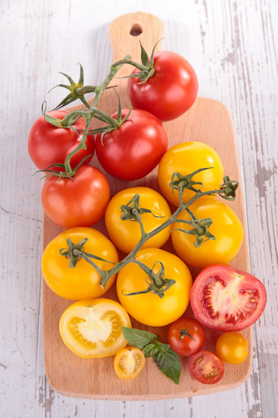 Red and yellow tomato on board - Фото, зображення
