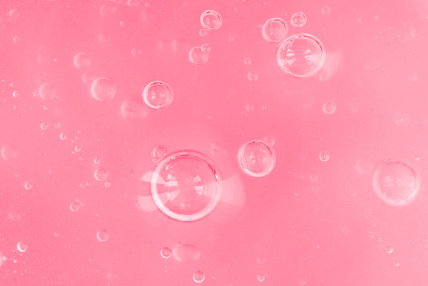 Texture de gel rose transparent avec bulles d'air et vagues sur fond blanc - Photo, image