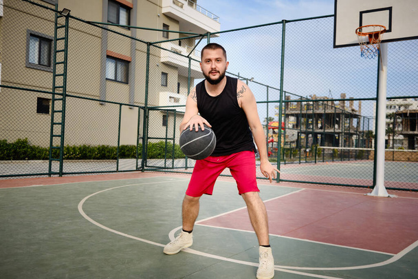 Man plays basketball at outdoor court - 写真・画像