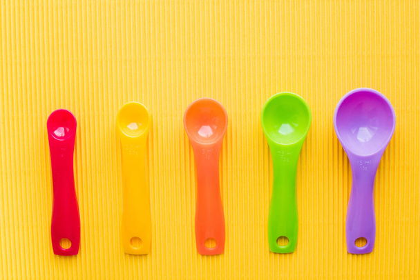 measuring spoons on yellow background  - Foto, imagen