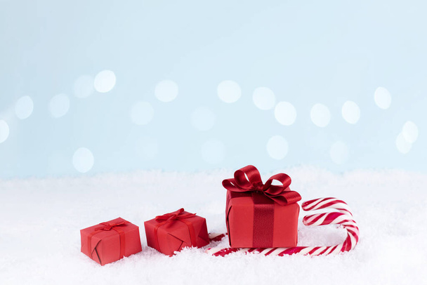 Сантівські сани виготовлені з червоного подарунка і цукерки на снігу з бокевим світлом, різдвяна концепція, копіювальний простір.. - Фото, зображення