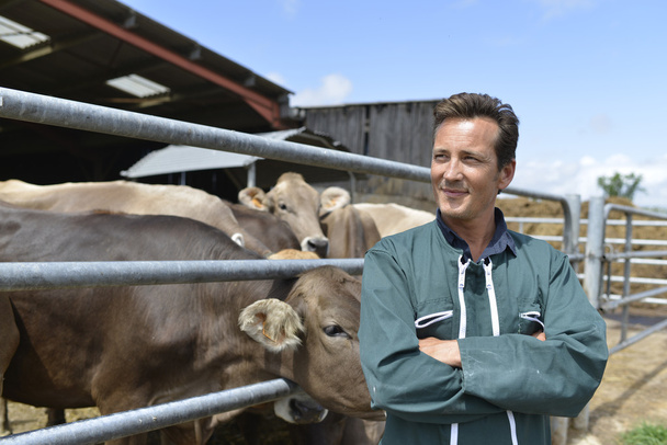 Smiling farmer standing by barn - Fotografie, Obrázek