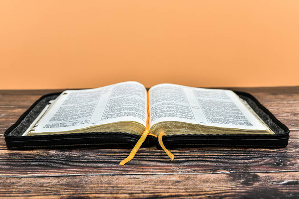 Открытая Библия с закладкой, готовая к чтению, лежит на столе. - Фото, изображение