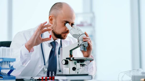 scientist studying vaccine samples through a microscope . - Φωτογραφία, εικόνα