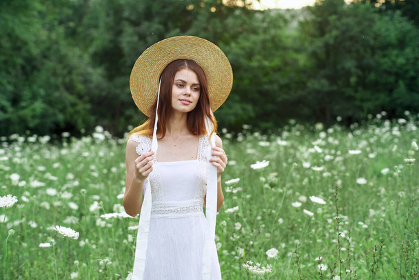 vrouw in witte jurk bloemen natuur wandeling charme - Foto, afbeelding