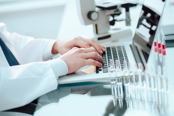 scientist works on a laptop in a medical laboratory. - Фото, зображення