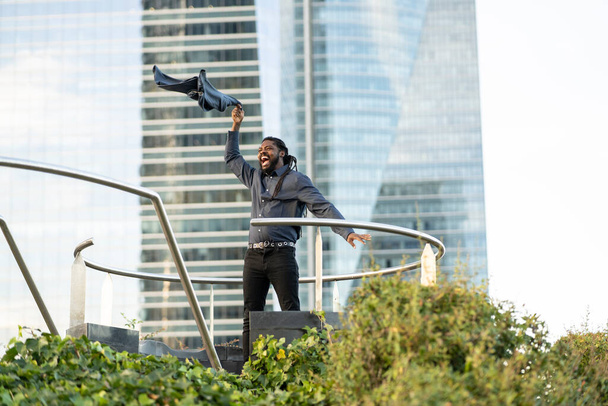 happy businessman leaving work throwing his jacket in the city - Foto, Bild