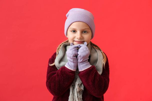 Klein meisje in stijlvolle winter kleding op kleur achtergrond - Foto, afbeelding