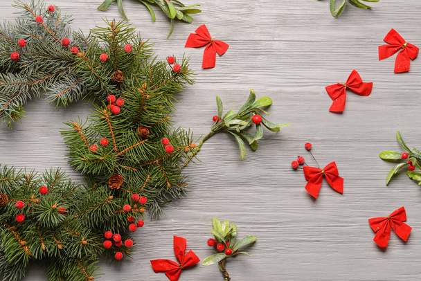 Beautiful Christmas wreath made of fir branches on grey wooden background - Fotó, kép