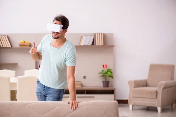 Fiatal férfi diák visel virtuális szemüveg otthon - Fotó, kép