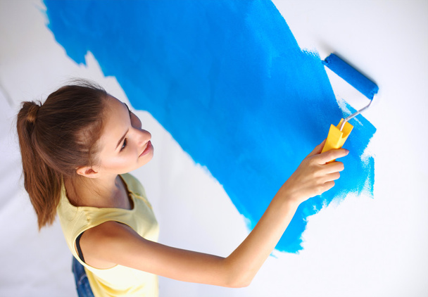 Happy beautiful young woman doing wall painting, standing on la - Foto, imagen