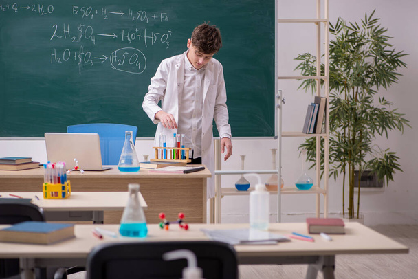 Школьник, изучающий химию в классе - Фото, изображение