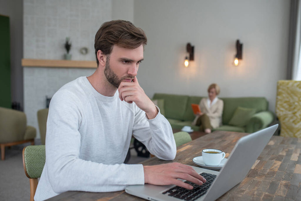 Young bearded man with a laptop working from home - Foto, immagini