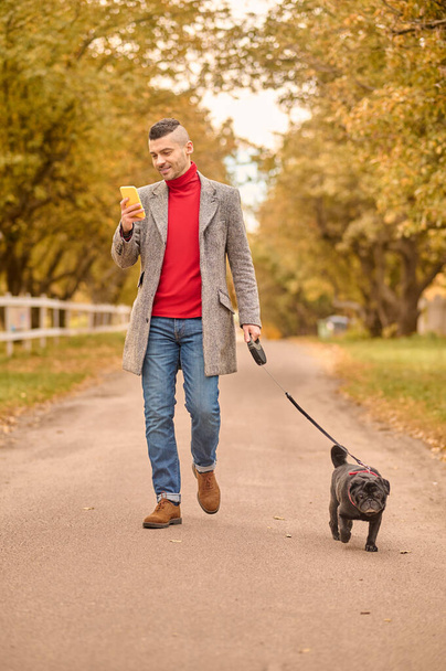 Man walking with a dog in a park - Photo, image