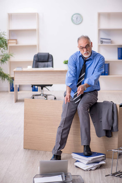 Ofisteki aşırı işten memnun olmayan yaşlı bir erkek işçi. - Fotoğraf, Görsel
