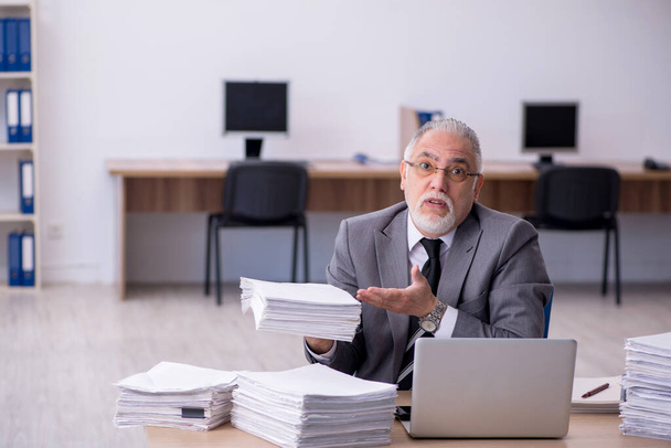 Stary mężczyzna pracownik niezadowolony z nadmiernej pracy w biurze - Zdjęcie, obraz