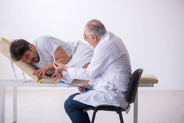 Vieux médecin psychiatre examinant jeune patient masculin - Photo, image