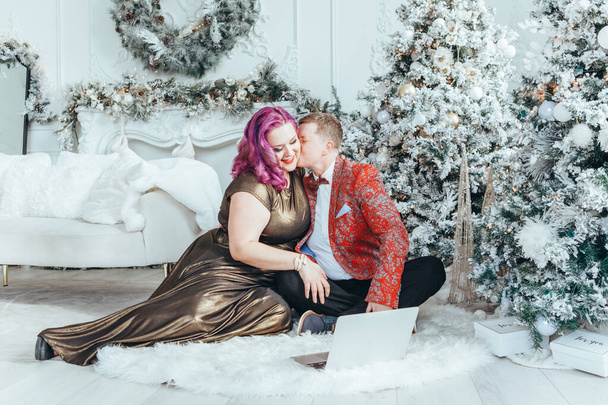 ЛГБТК-гомосексуальная пара празднует Рождество или Новый год. Молодая женщина-гей с партнером-бучем звонит друзьям и семье онлайн на ноутбуке. - Фото, изображение