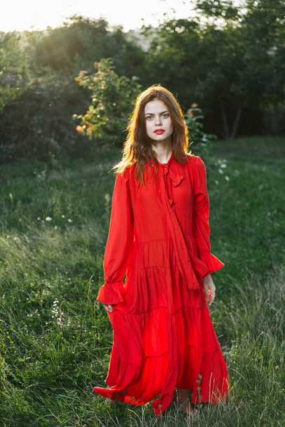 attractive woman in red dress outdoors in freedom field - Fotoğraf, Görsel