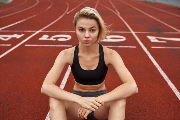 Blonde confident sports woman on stadium treadmill - Fotó, kép