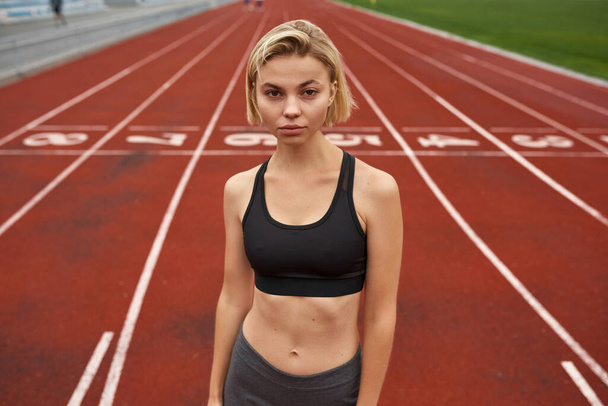 Young caucasian sports woman on stadium treadmill - Photo, image
