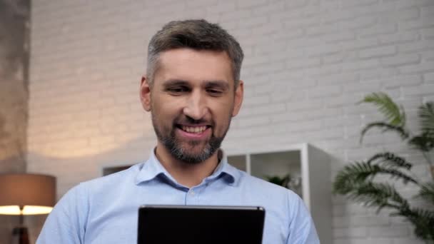 Közelkép mosolygós férfi kereskedő néz tabletta elemzi jegyzések tőzsde - Felvétel, videó