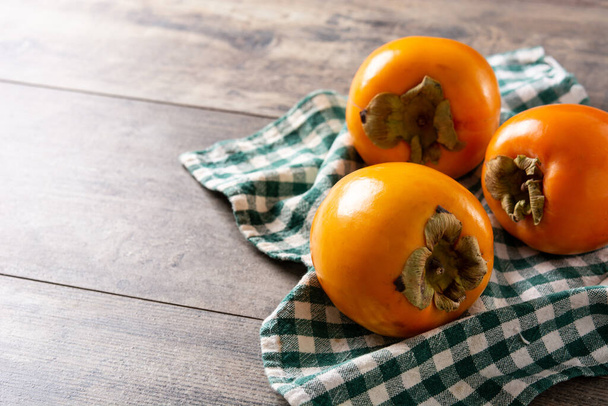 木のテーブルに新鮮な柿の実。スペースのコピー - 写真・画像