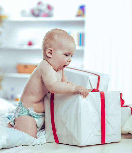 one year old cute baby playing with shopping in boxes on the sof - Valokuva, kuva
