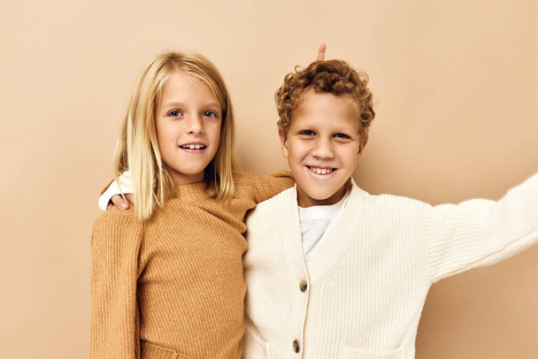 niño y niña en suéteres de fondo beige - Foto, imagen