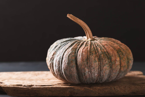 Organic Asian pumpkin on wooden with black background, Still Life - Photo, image