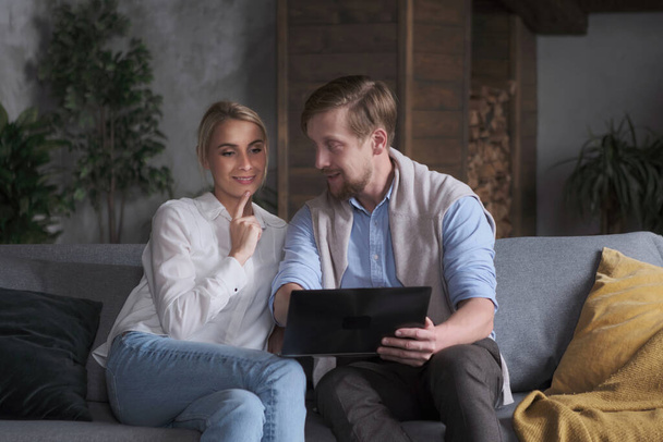 Mąż i żona omawiają zakupy online razem surfing Internet za pomocą laptopa - Zdjęcie, obraz