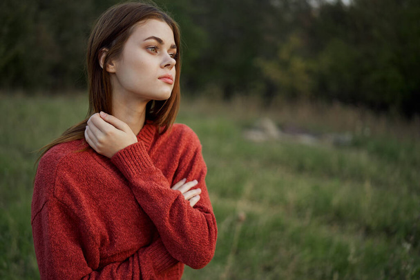 woman in a red sweater outdoors in a field walk - Photo, Image