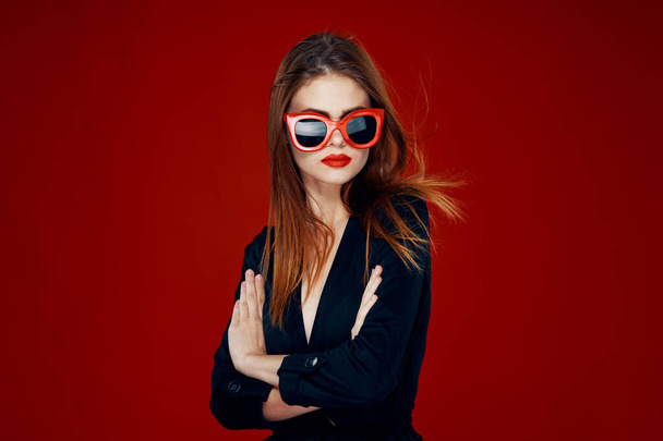 pretty woman wearing sunglasses fashion posing hairstyle red background - Fotoğraf, Görsel